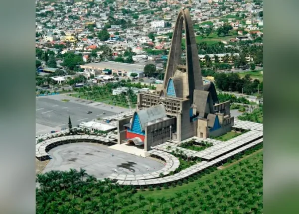 A church with a large spire in the middle of it.