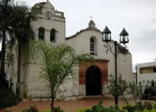 A white church with a clock tower and a large entrance.