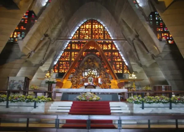 A church with stained glass windows and a red carpet.