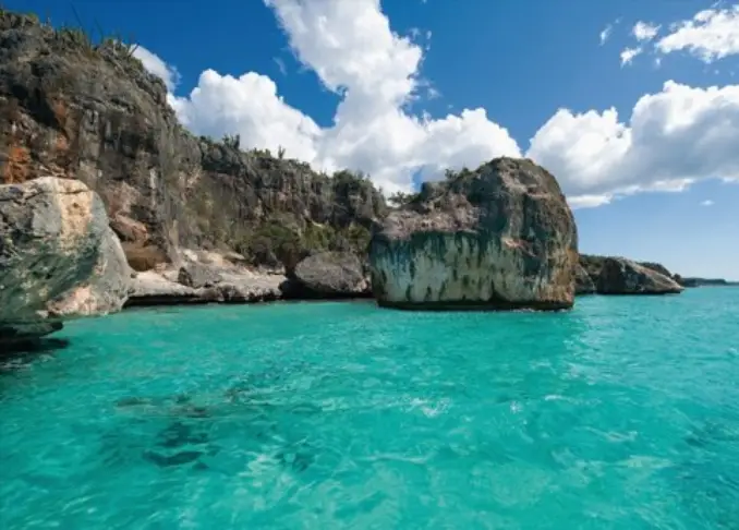 A body of water with some rocks and trees