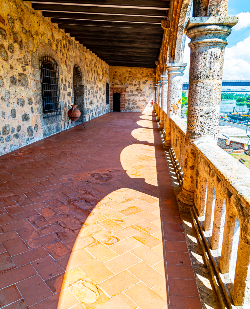 A long walkway with pillars and stone walls.