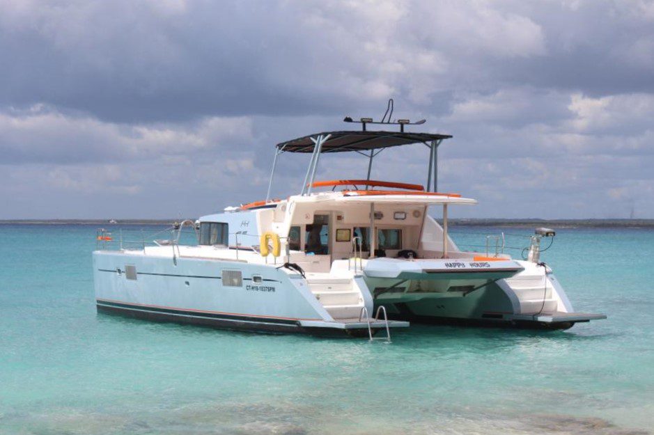 A boat is docked in the water near some trees.