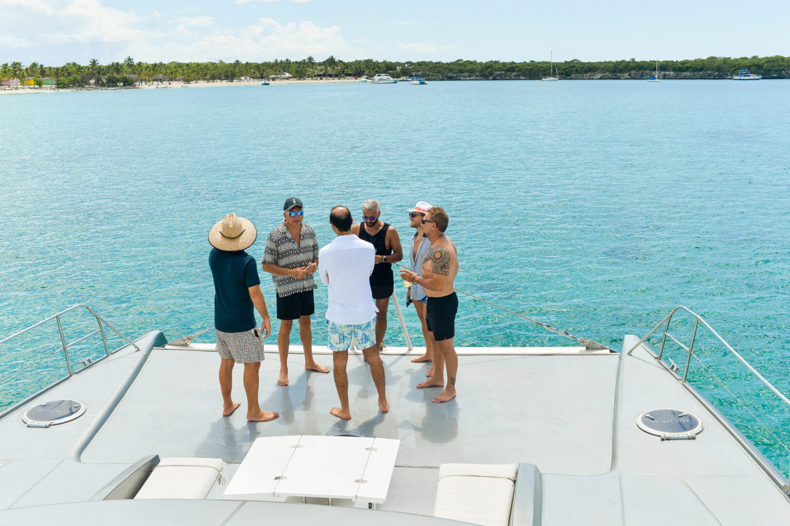 A group of people standing on the side of a boat.