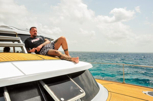 A man laying on the hood of a boat.