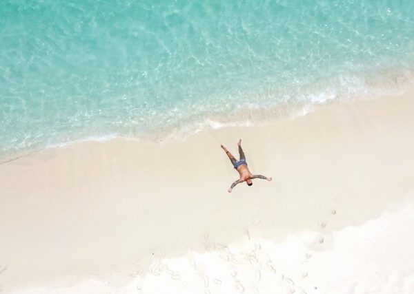 A person laying on the beach in the sand