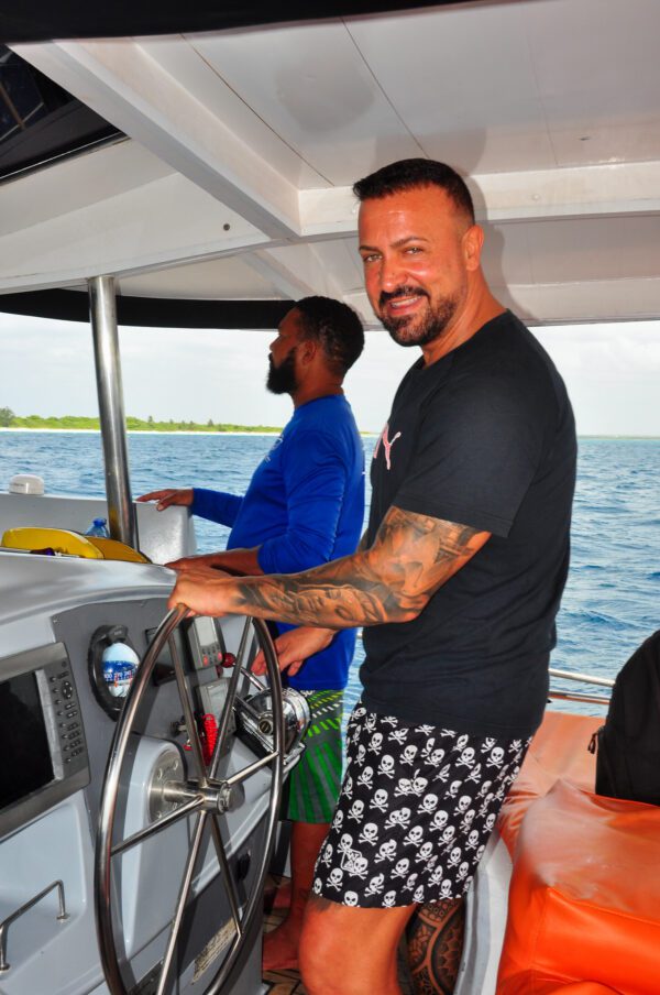 Two men on a boat in the water.