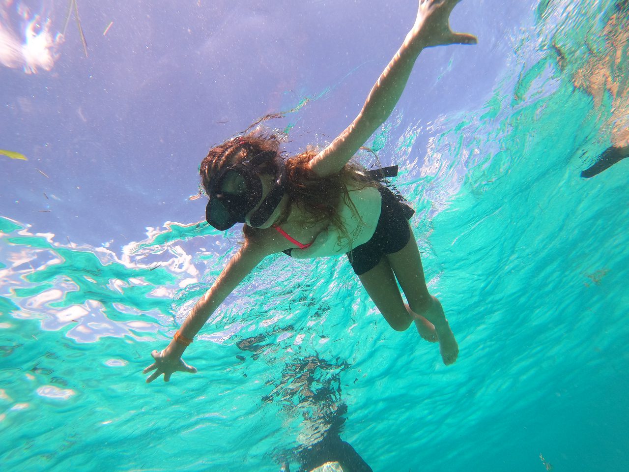 A woman swimming underwater in the ocean.